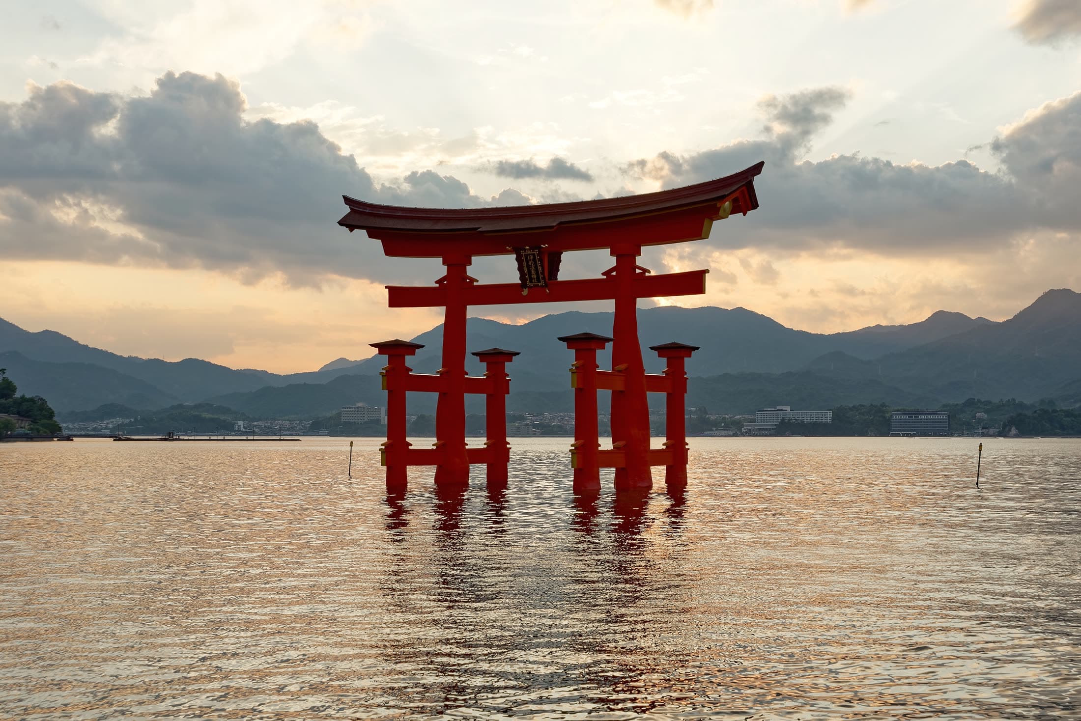 Itsukushima torii standing in calm water under an evening sky